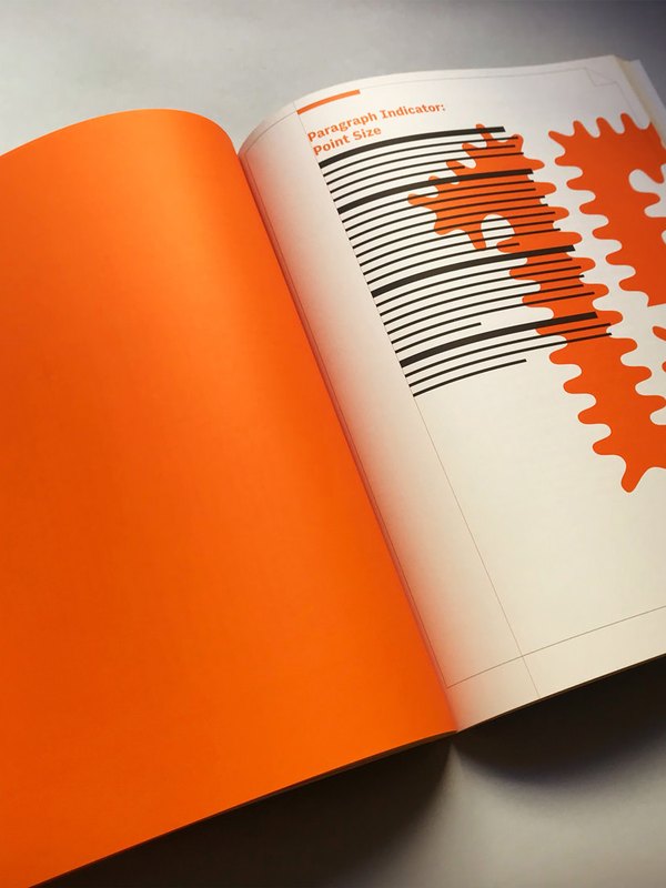 The paperback open at Paragraph Indicator: Point Size, a full fluorescent orange page facing lines of type overlaid with orange splashes.